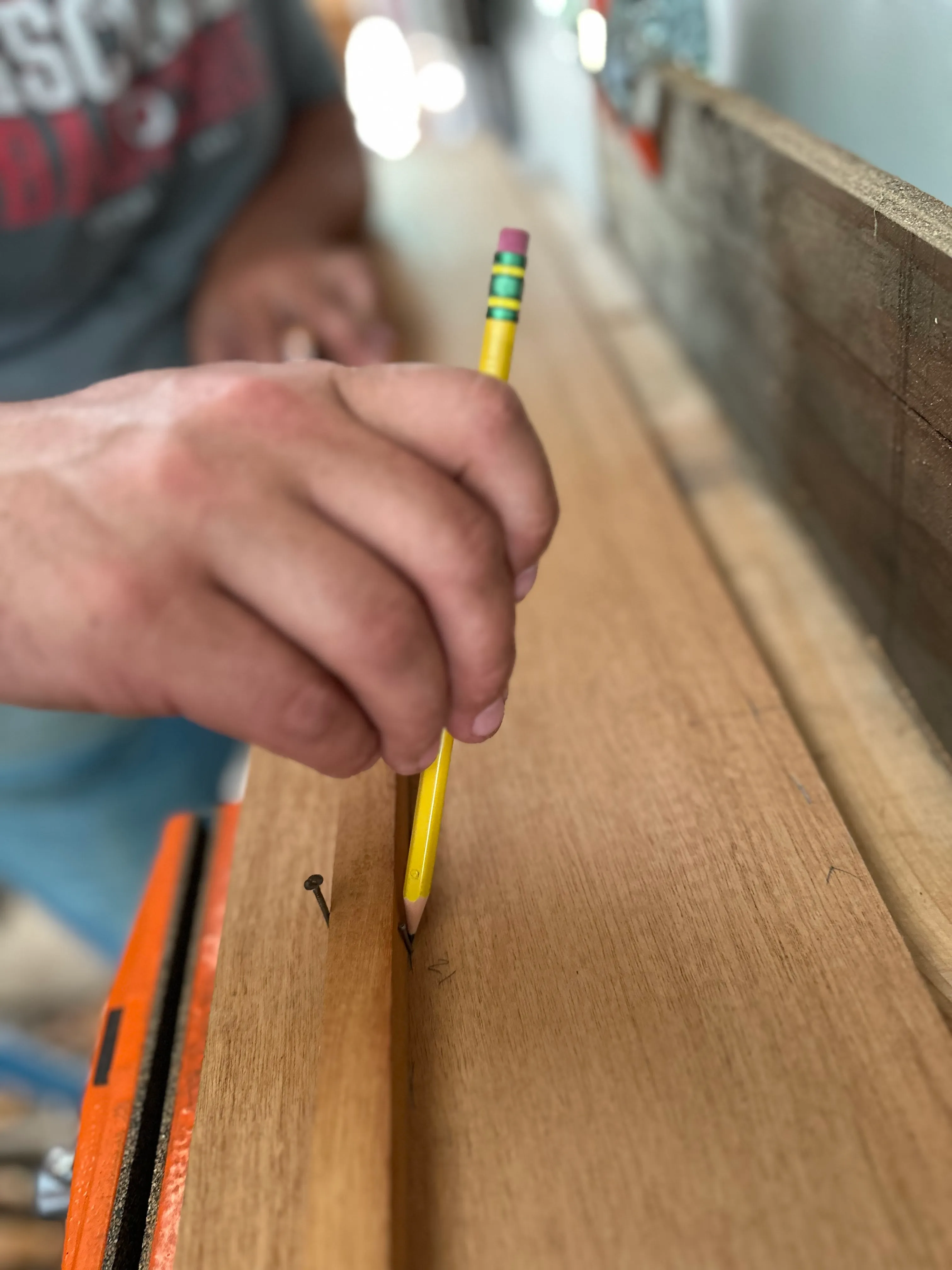 Hand marking spiling points on a plank with a pencil