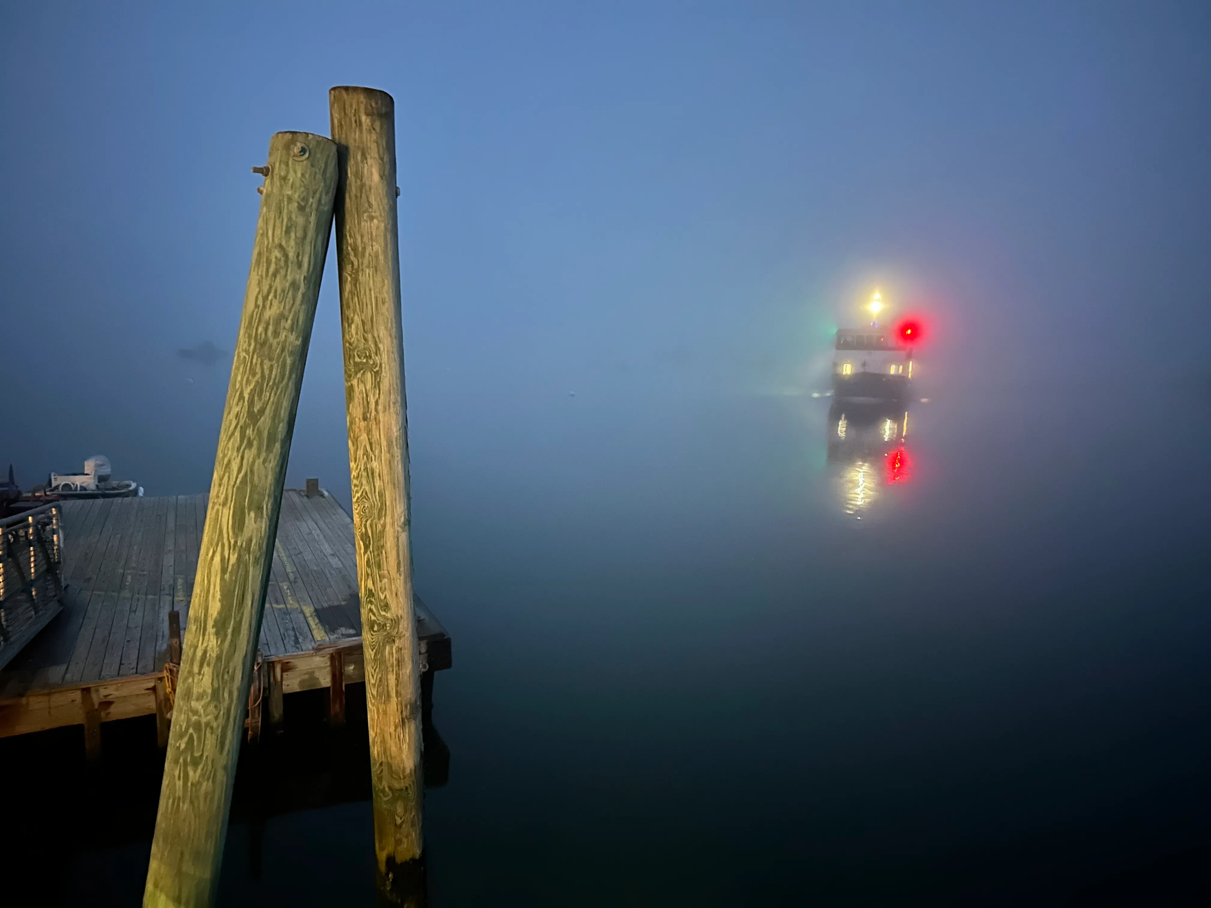 Ferry lit up at night in fog on the water