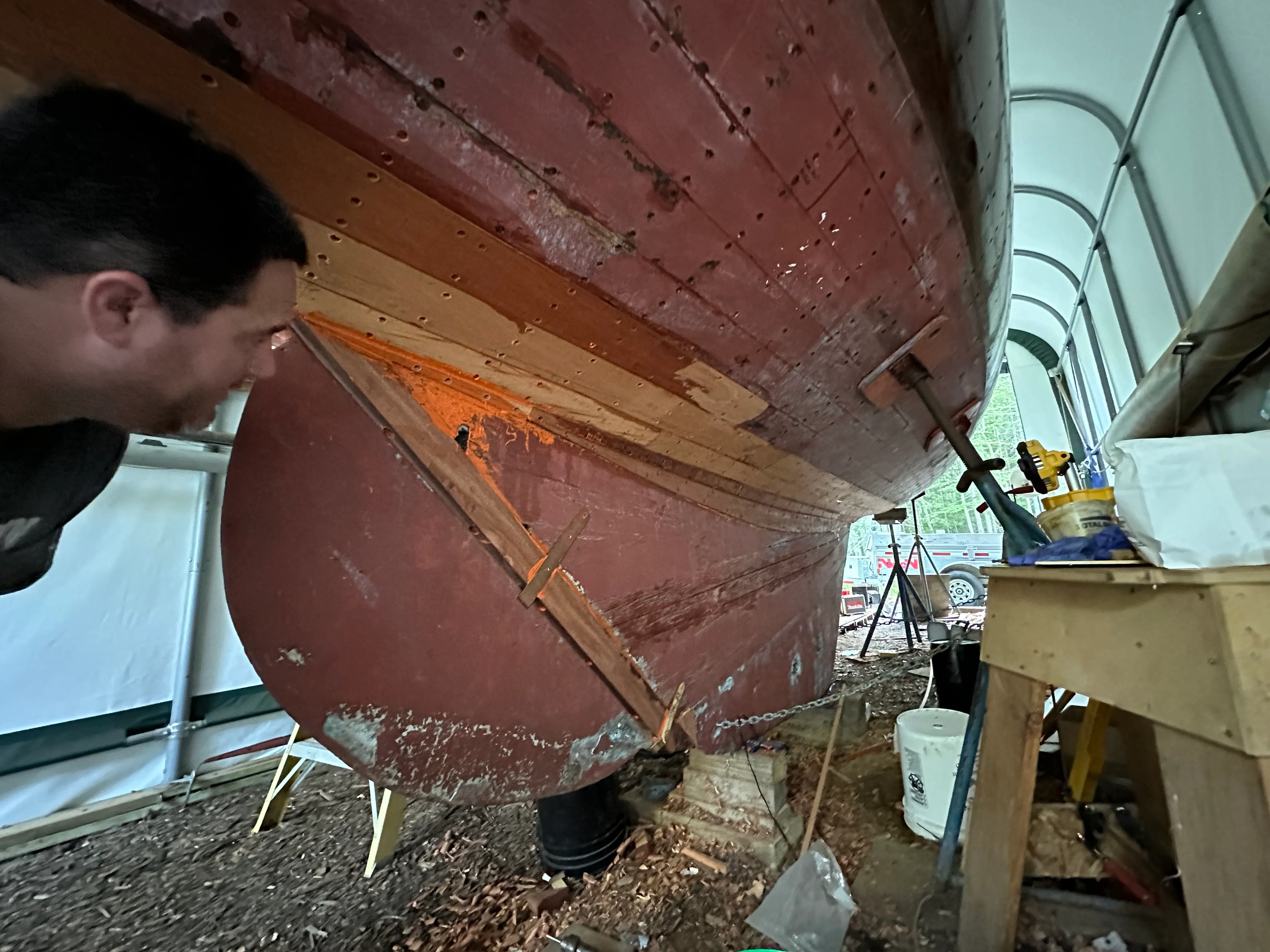Person standing back to inspect the hung rudder and stern from a distance