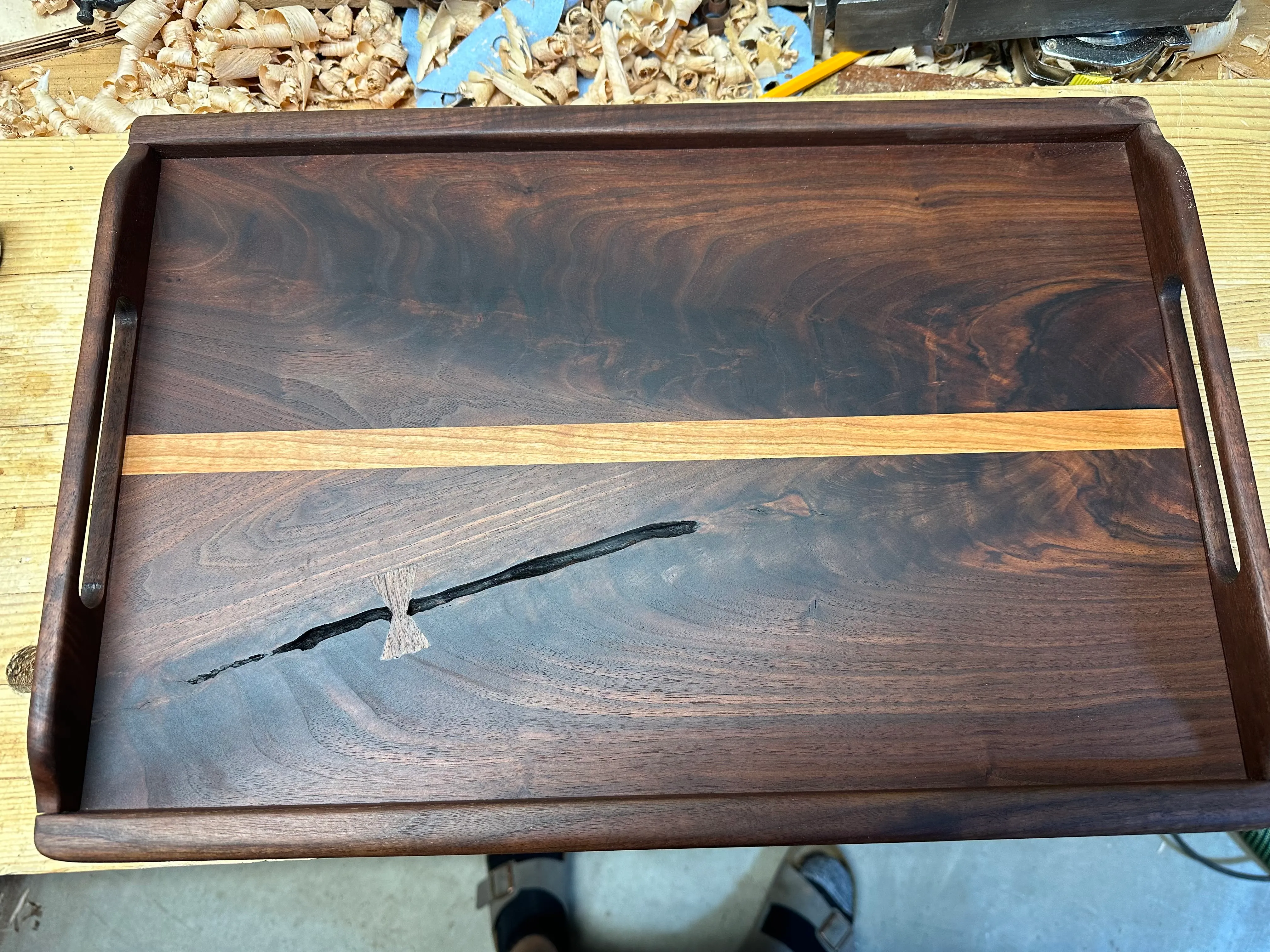 Top-down view of the finished walnut tray with bow tie, maple strip, and walnut frame
