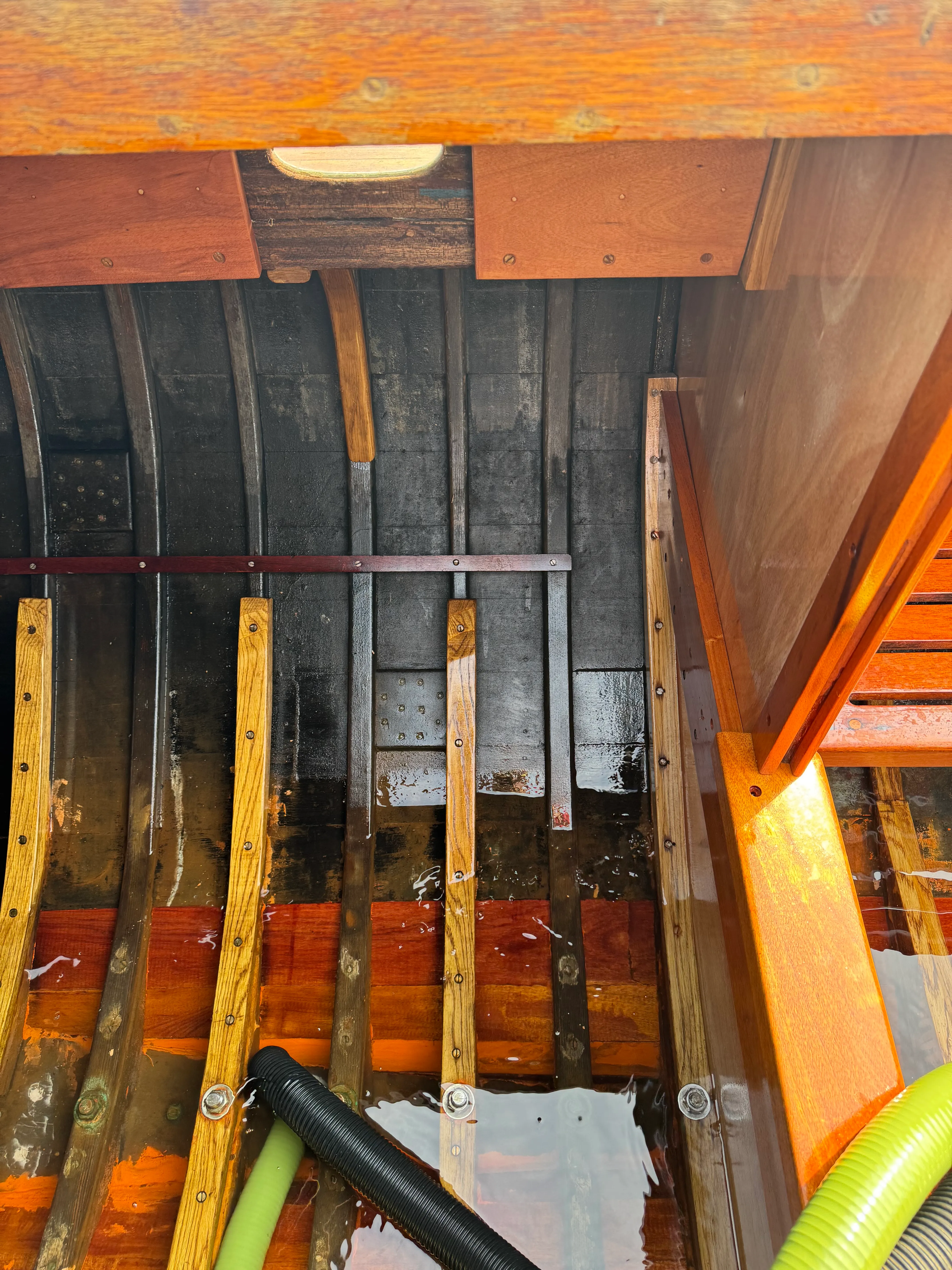 Close-up of the bilge showing water seeping in between planks and frames