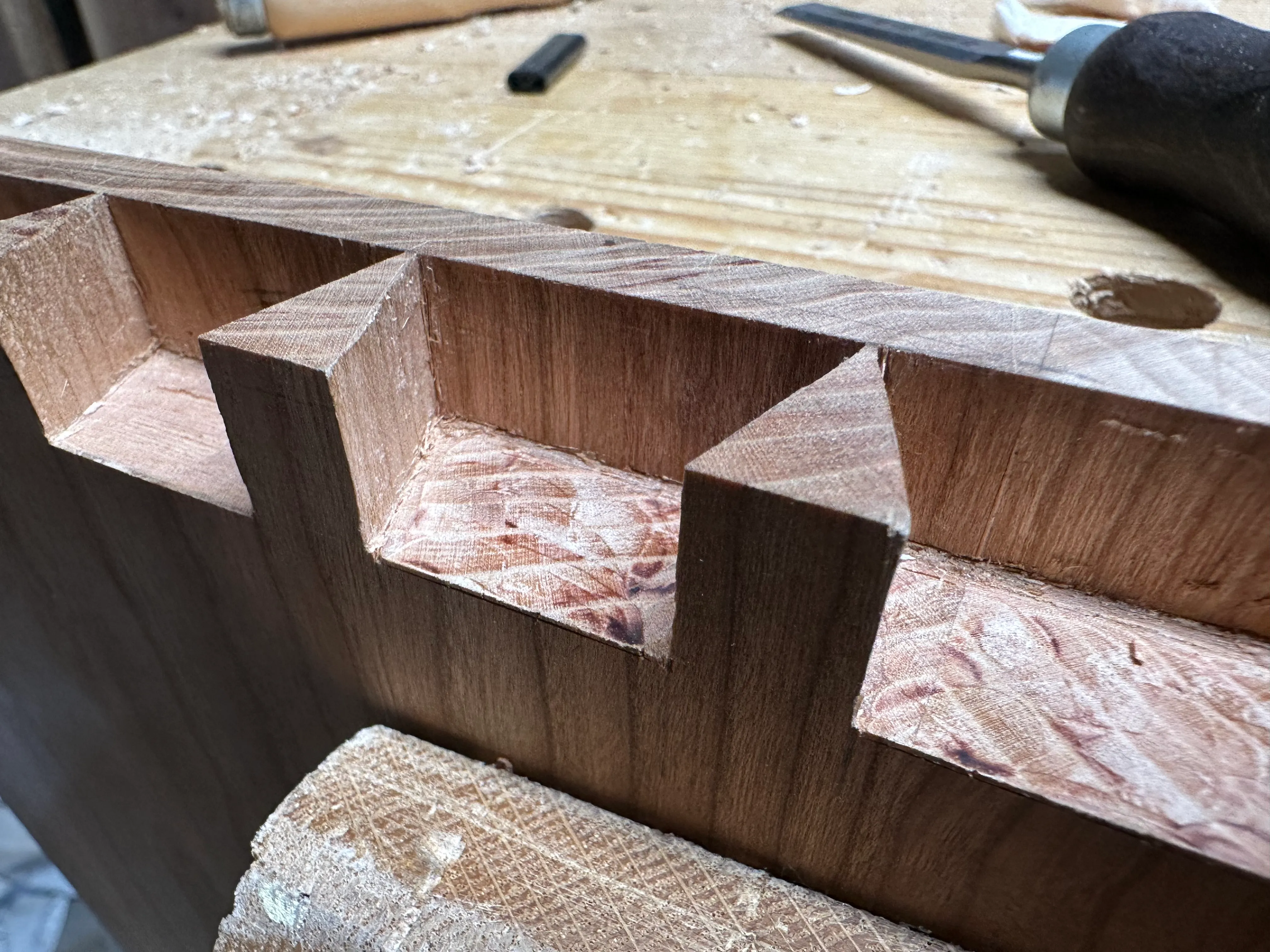 Close-up of half-blind dovetail tails cut in cherry drawer front