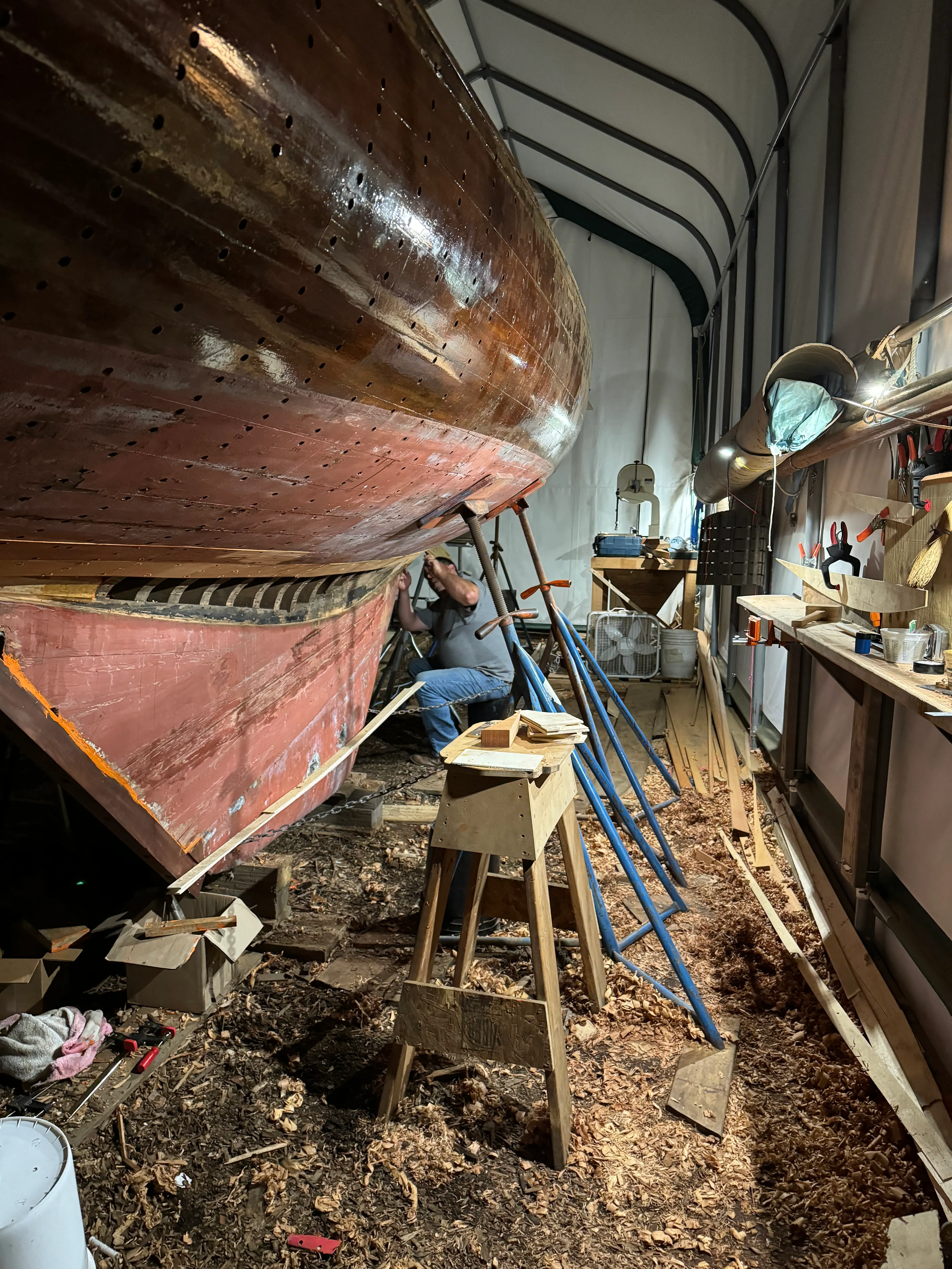 Wide shot of person working on the hull planking