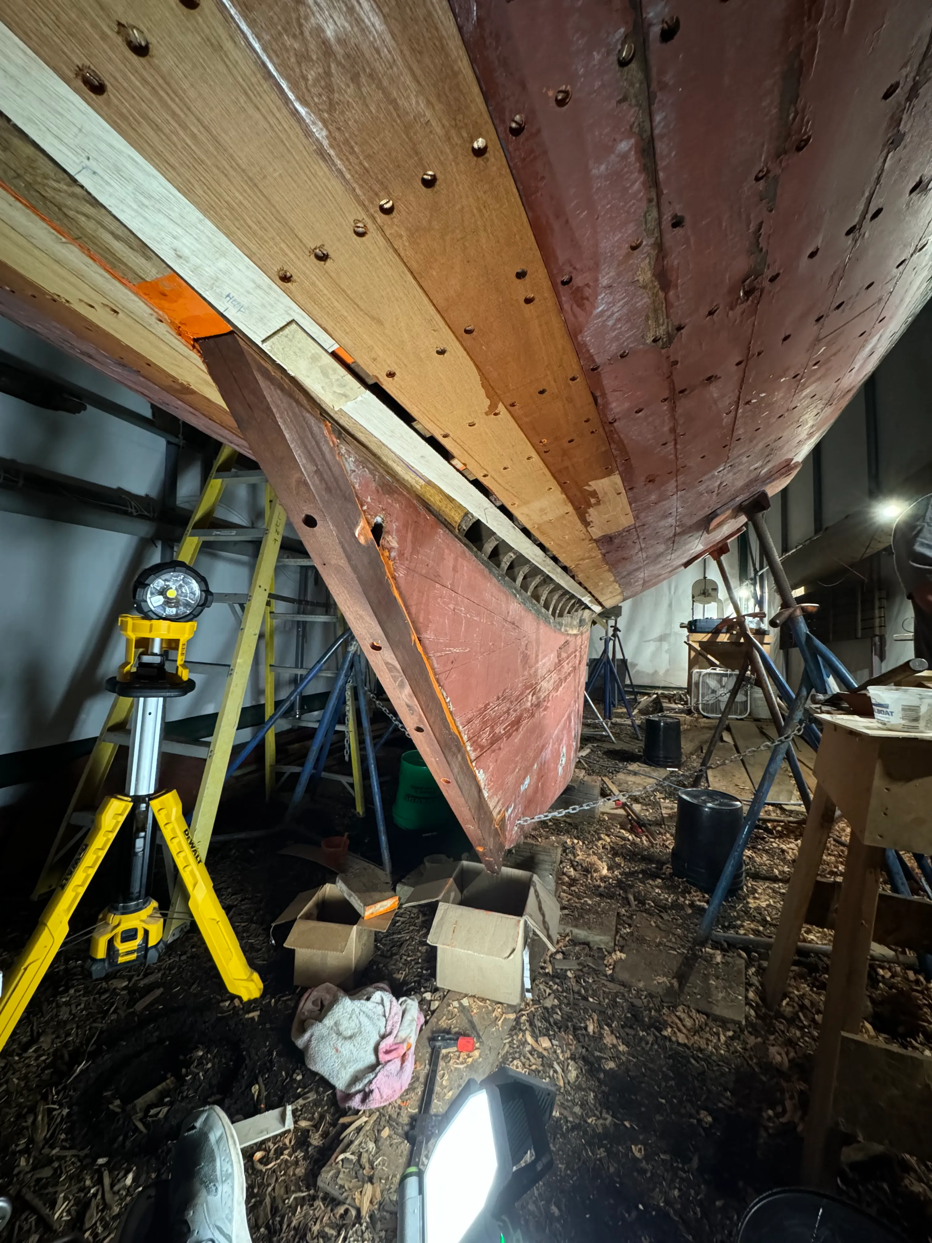 Long spiling board made of door skin with a plywood hood end template hot-glued to the end, held against the hull