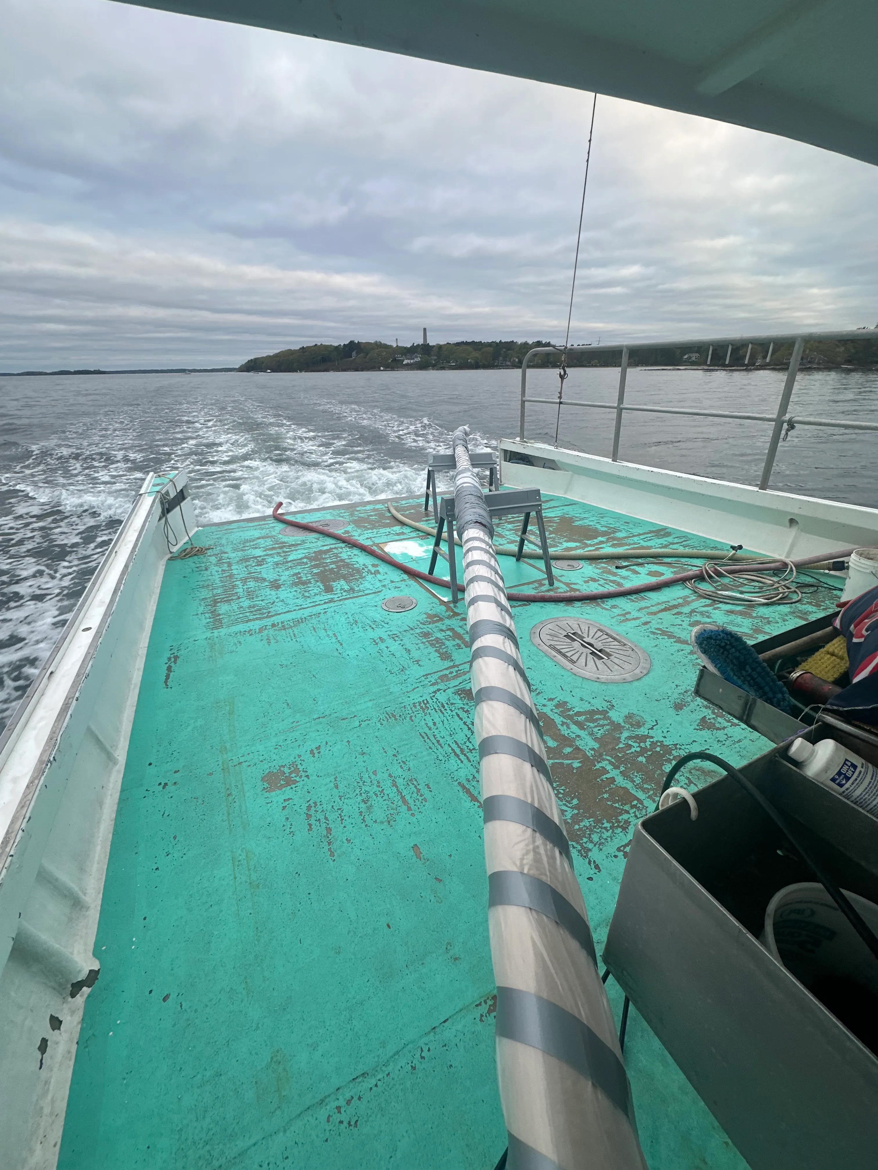 New mast being transported on the back of a lobsterboat