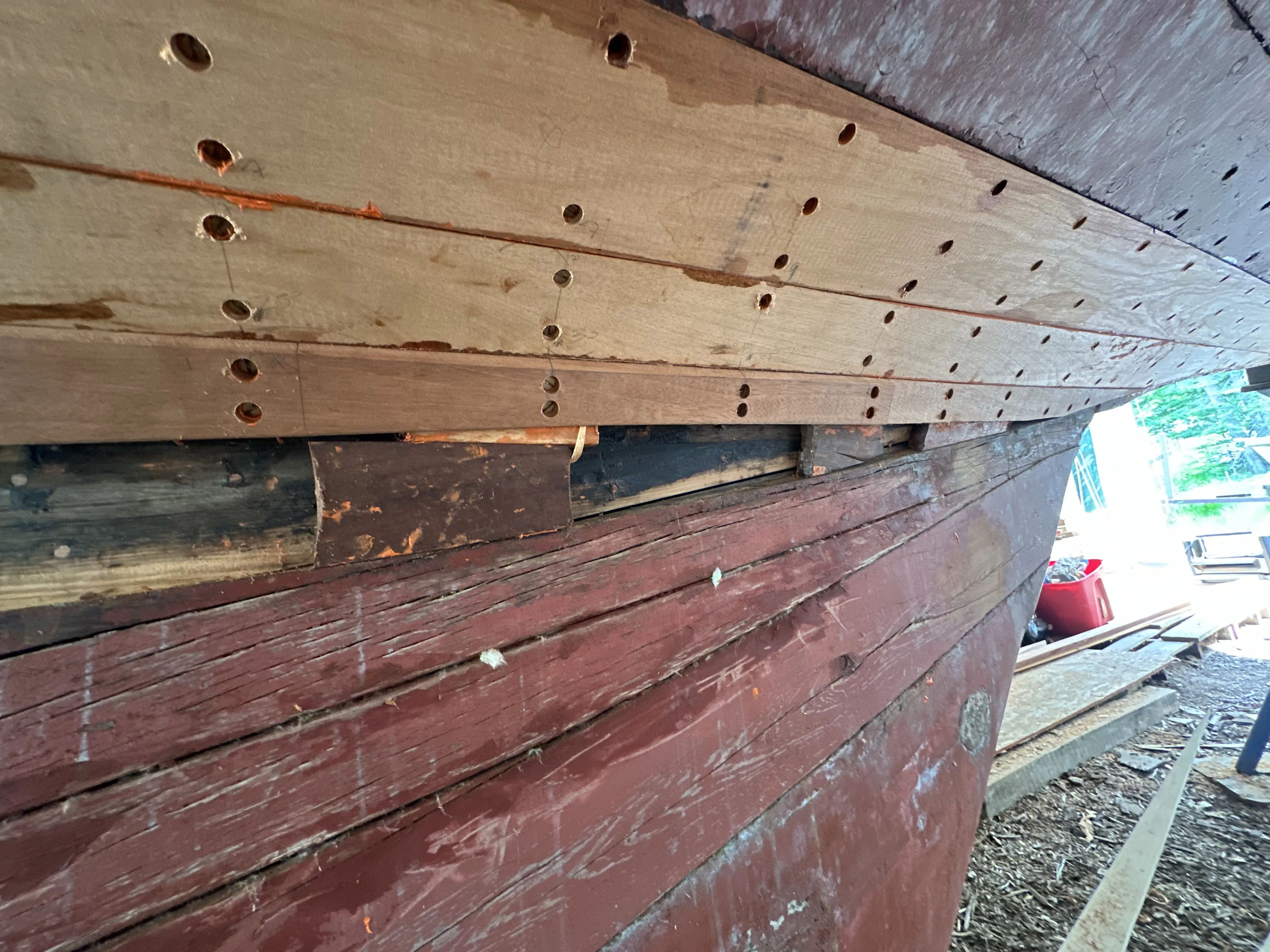 New planks fitted on the hull with wedges visible at frame locations